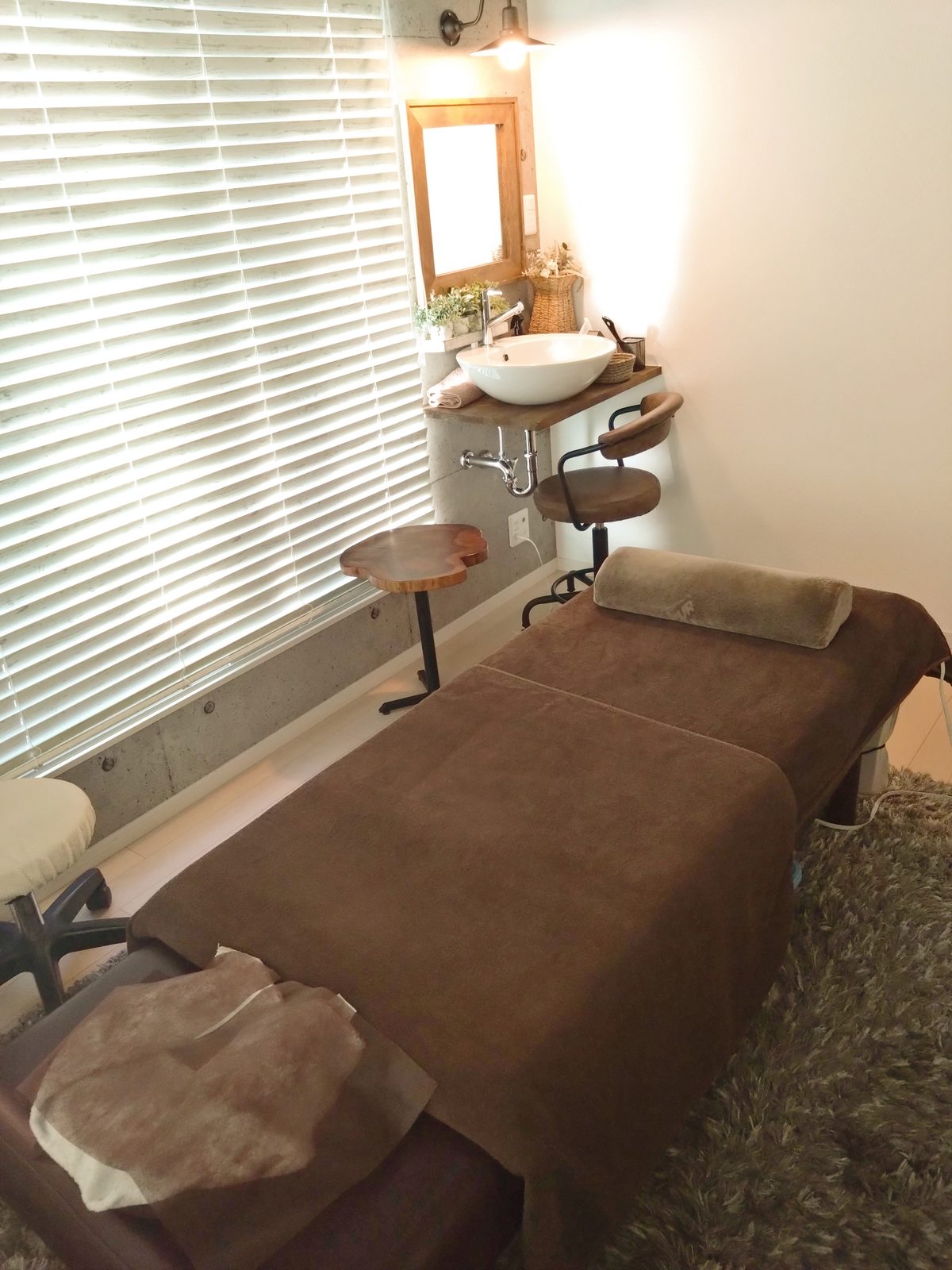 ほぐし処 Heal nap n. の施術室。ベッドと洗面まわりが写っており、壁に時計は掛かっていない